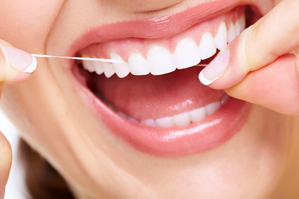 Close up of woman flossing her teeth